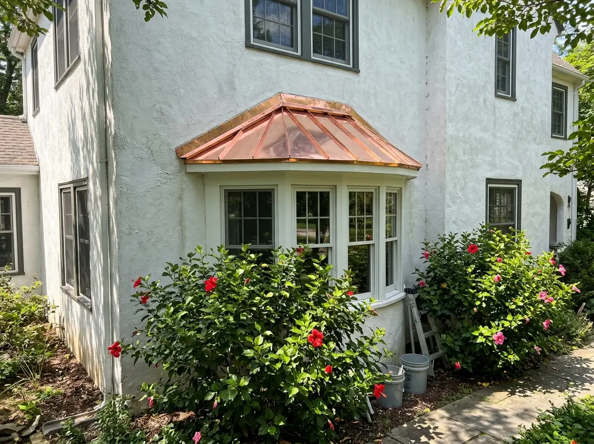 New copper standing seam roof over a curved bay window on a stucco home