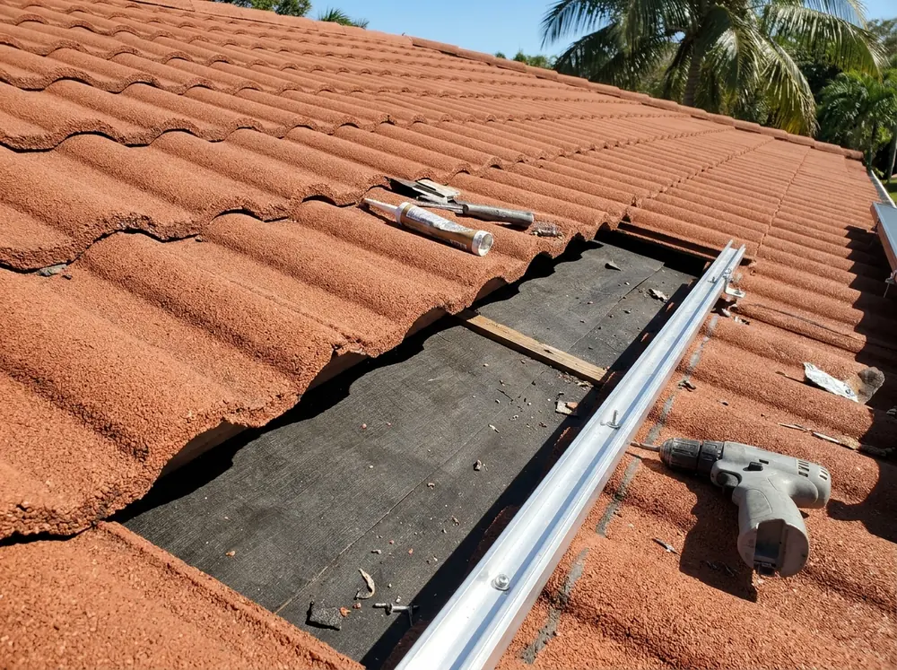 Stone-coated steel barrel-profile roof with one course of panels lifted and a solar mount fastened to the deck beneath